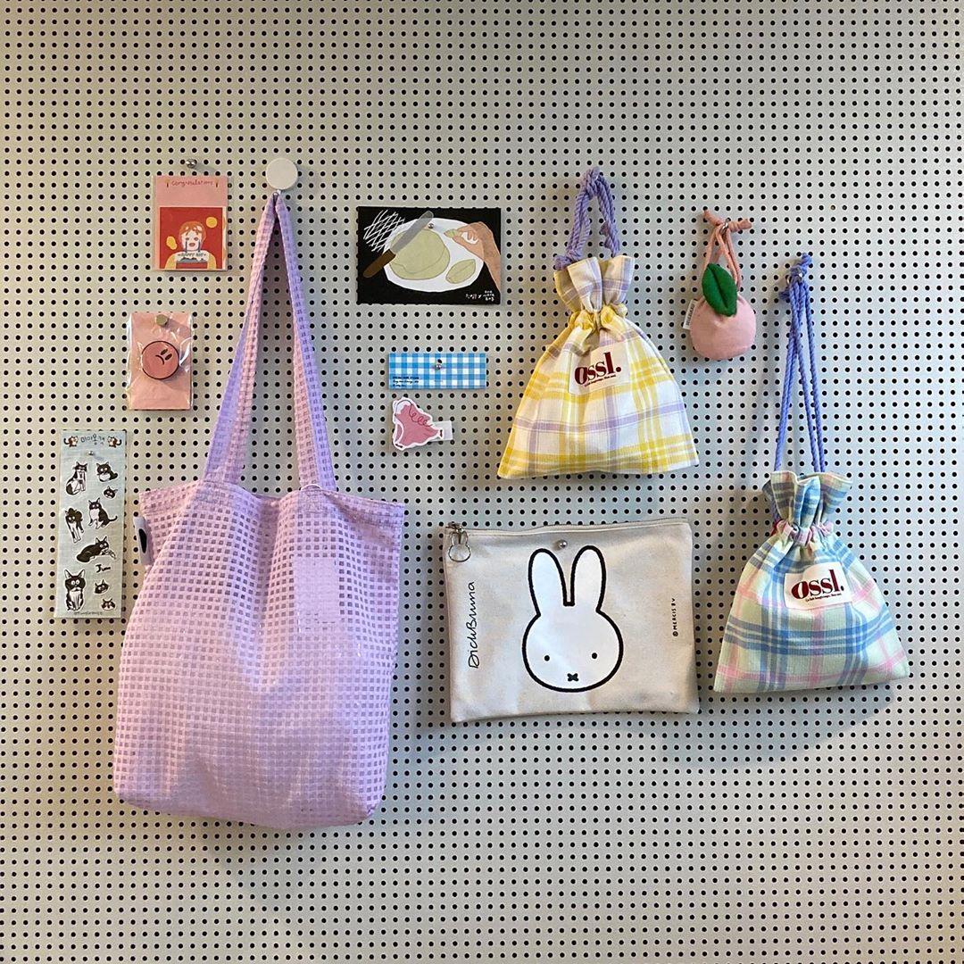 バッグとキャラクターの小物が壁にディスプレイされた韓国雑貨店の一角。カラフルでかわいいアイテムが並んでいます。