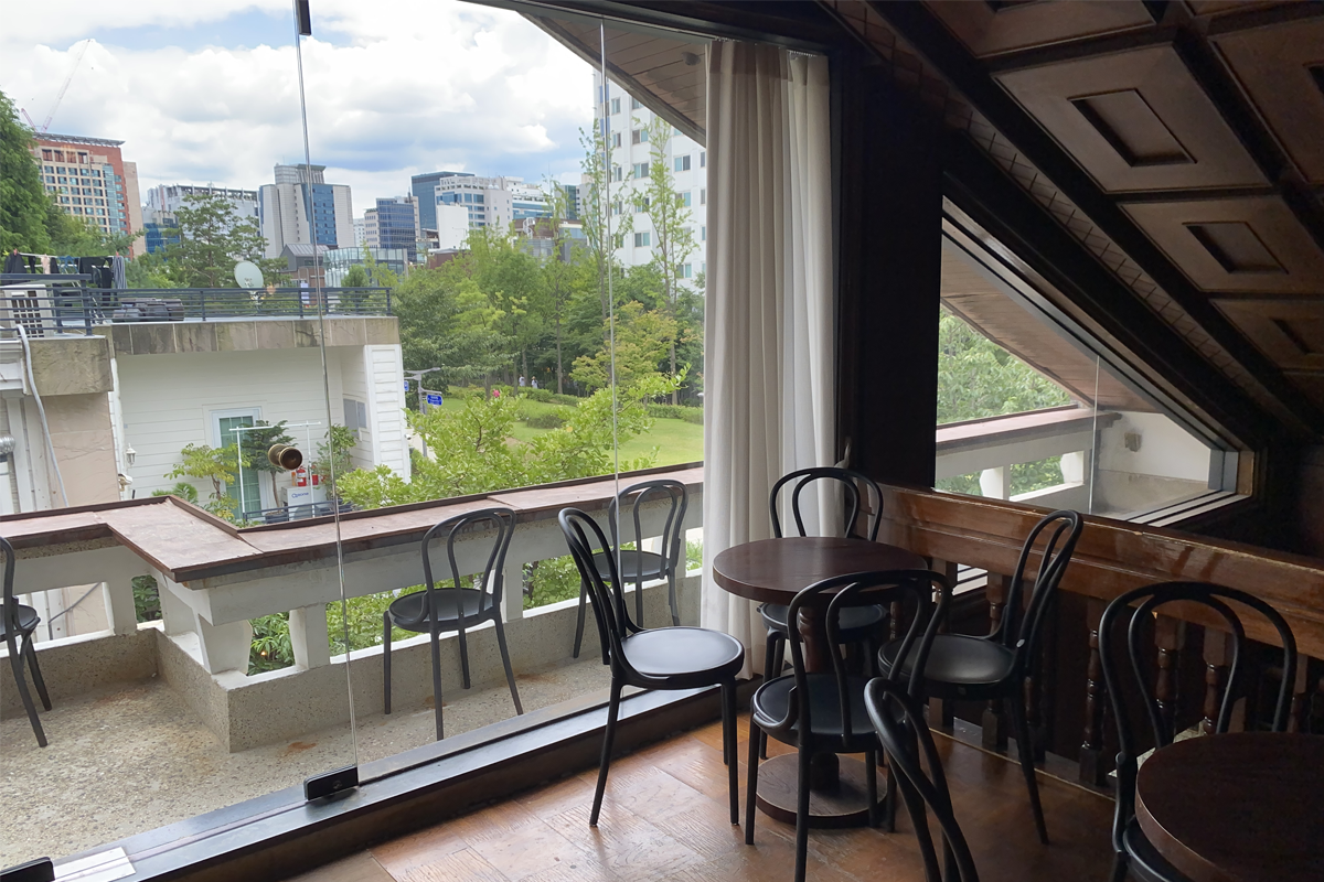 延南磨坊的室內座位區,包括落地窗的閱讀區,與木製桌椅的古典氛圍。