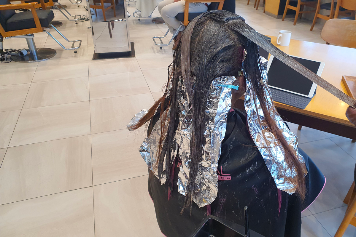 MERCY HAIR正在进行专业发型服务，美发师小心上色以确保顾客满意。