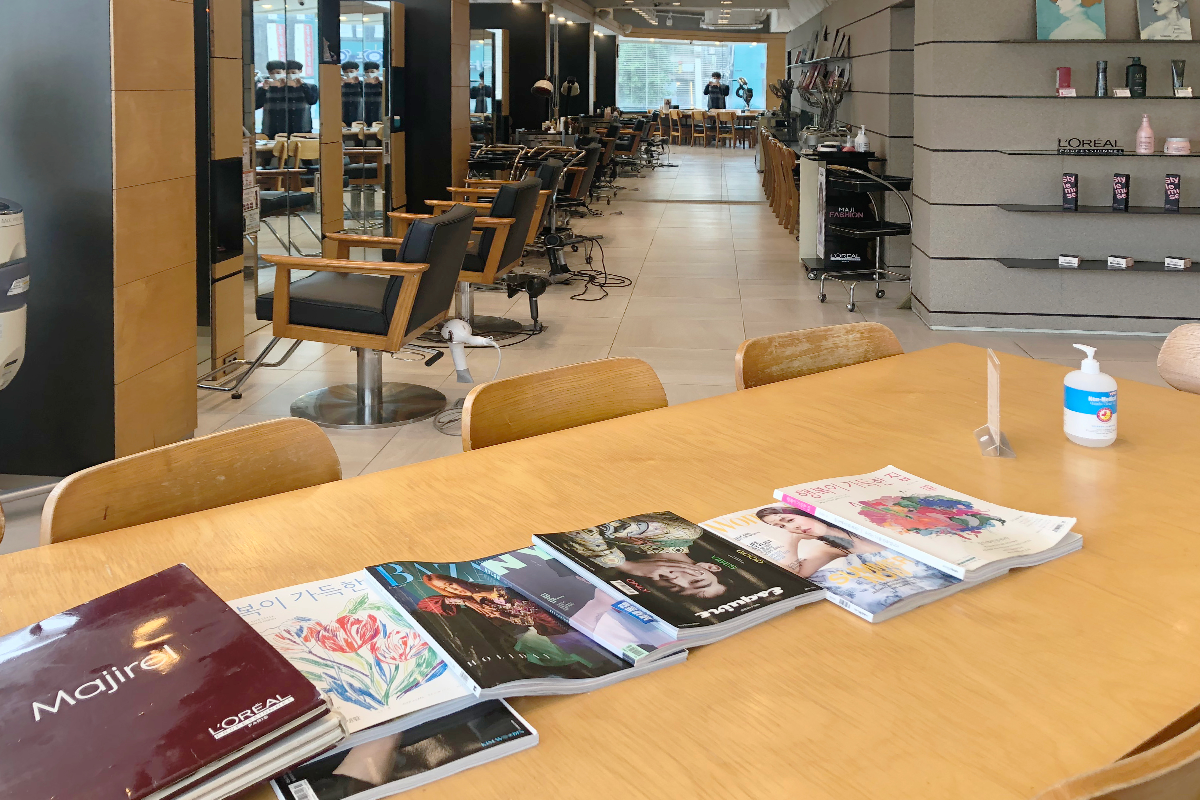 MERCY HAIR美容院的等待区，摆放着多本时尚杂志供顾客阅读。