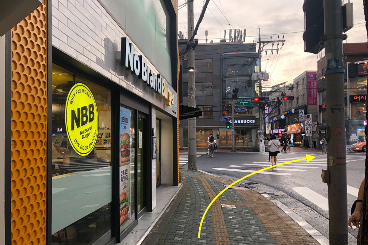 No Brand Burger餐厅附近的街道，标识了去往MERCY HAIR的方向。