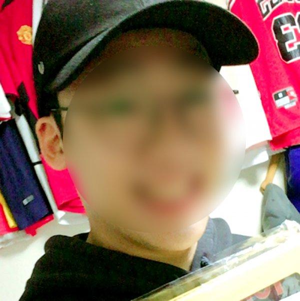 帽子をかぶった人物が見える室内の写真で、背景には飾られた布が見えます。