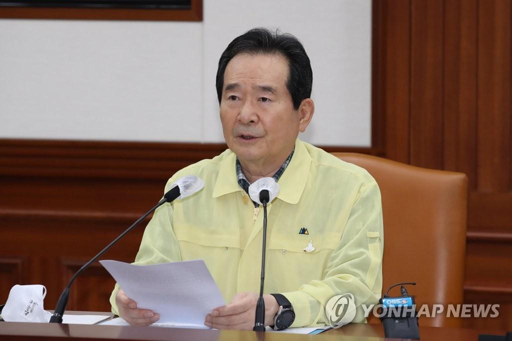 政府会議で社会的距離置きの強化を発表する場面。中央災難安全対策本部会議にて、書類を持って準備する人物がいる。