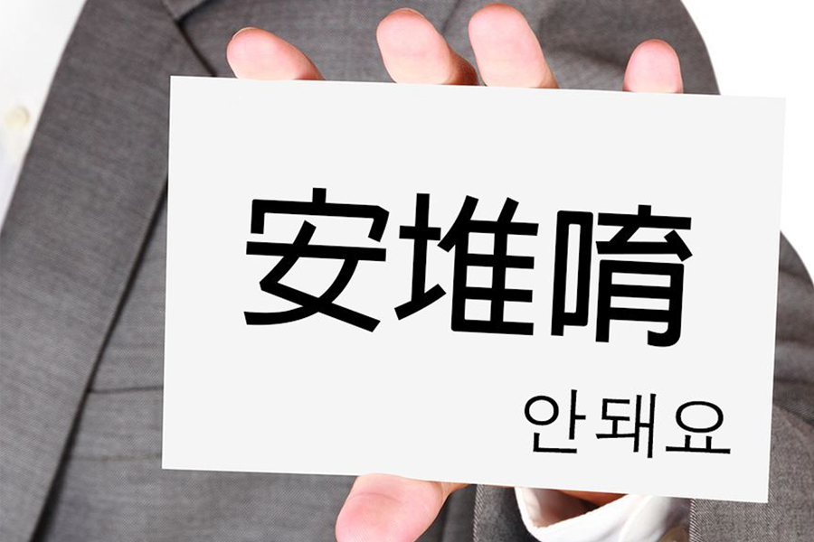 手持寫著韓文『안돼』和中文『安堆唉』的標語，說明『안 되』與『안 돼』的韓文常犯錯誤用法。