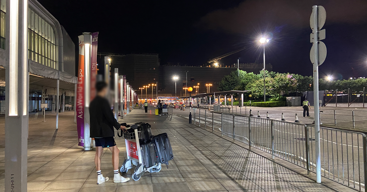 旅客在香港機場外的夜晚環境，準備離開機場的情景