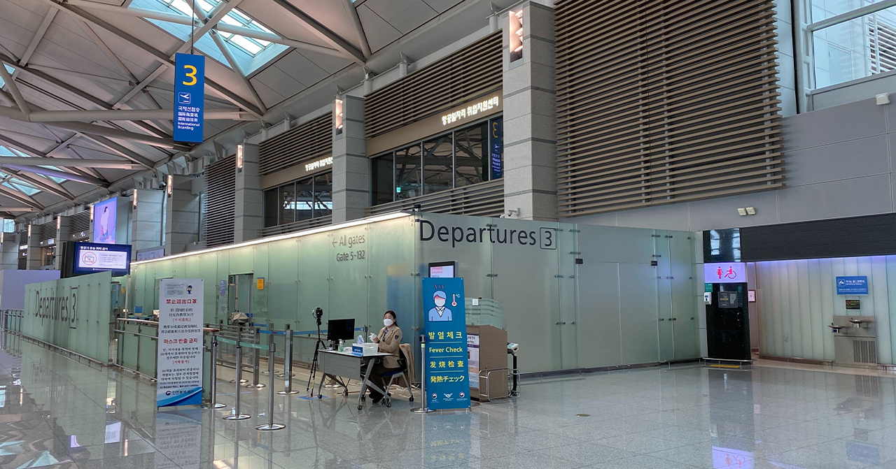 香港機場候機區，顯示登機口和出發方向的標牌