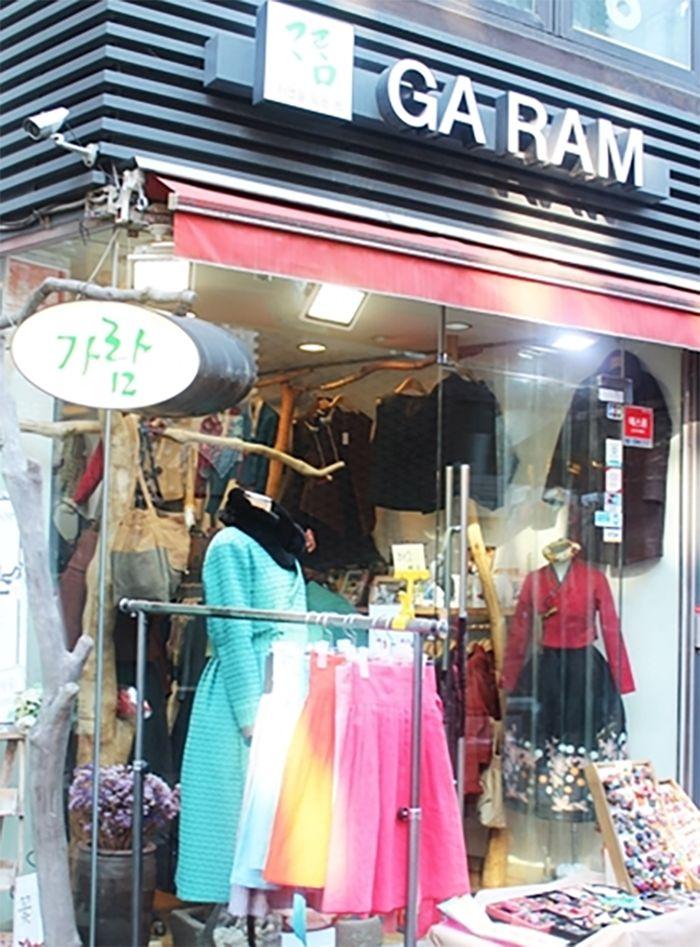 Entrance to a hanbok store featuring colorful traditional and modern attire
