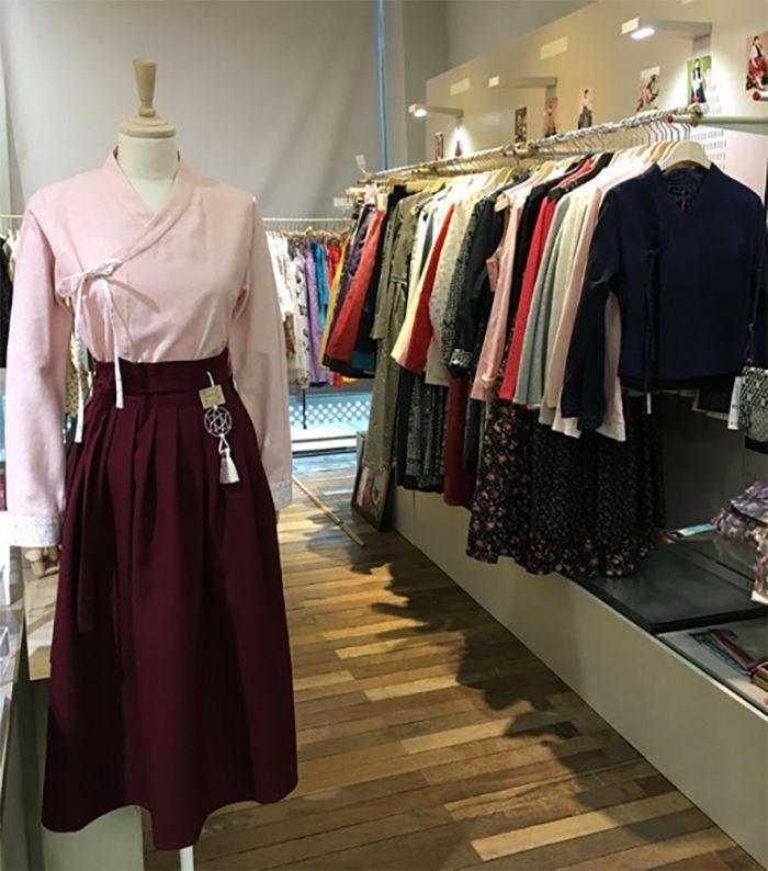 Vibrant hanbok dresses and accessories displayed in a contemporary store layout