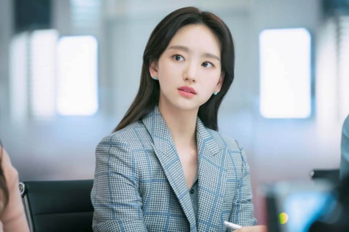 《前辈，那支口红不要涂》中的演员在会议室的剧照，展现角色在工作场景中的专注状态。