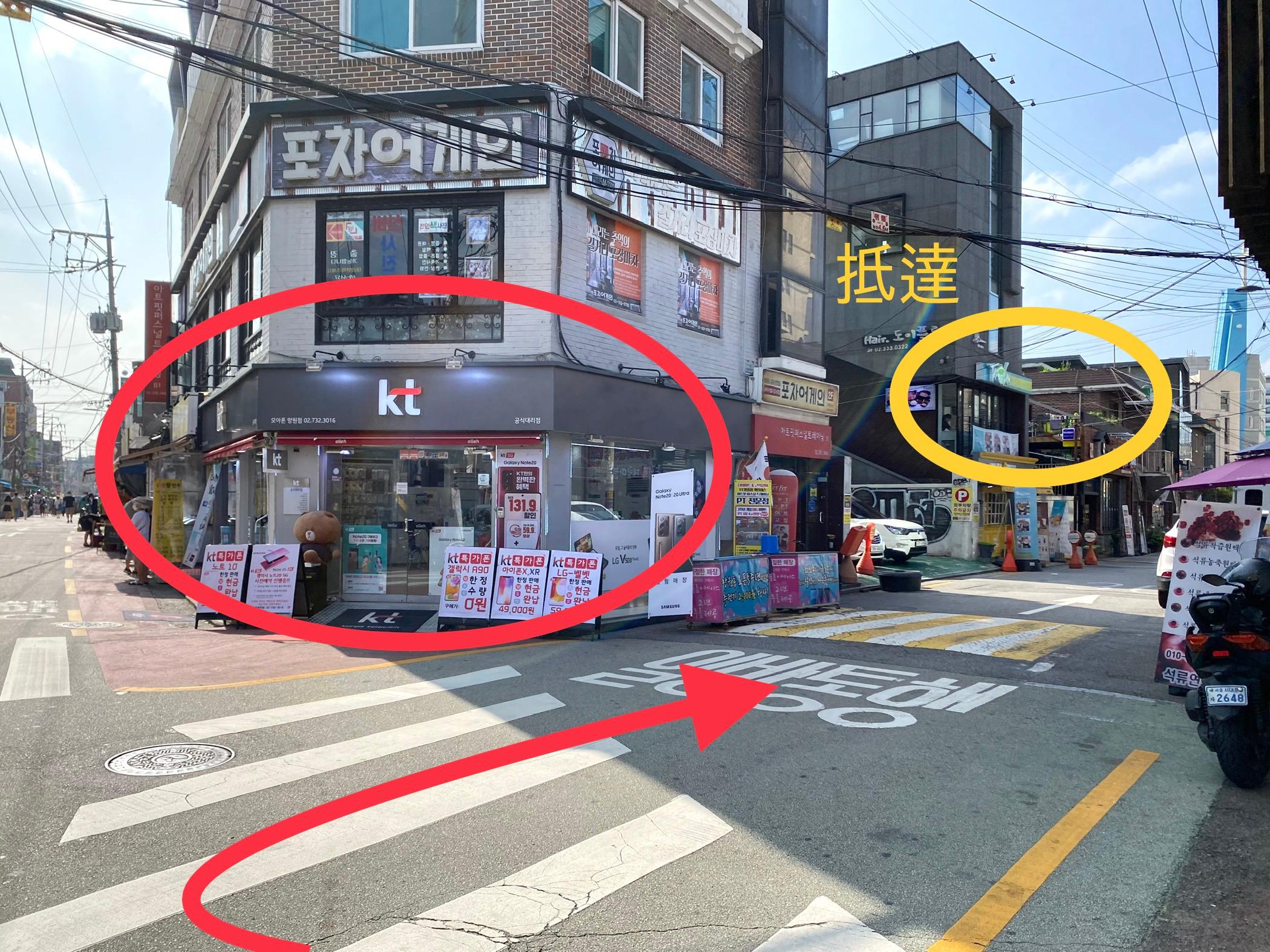 望遠區靠近KT門市及臺灣火鍋專賣店的街角，紅色及黃色標記指出方向。