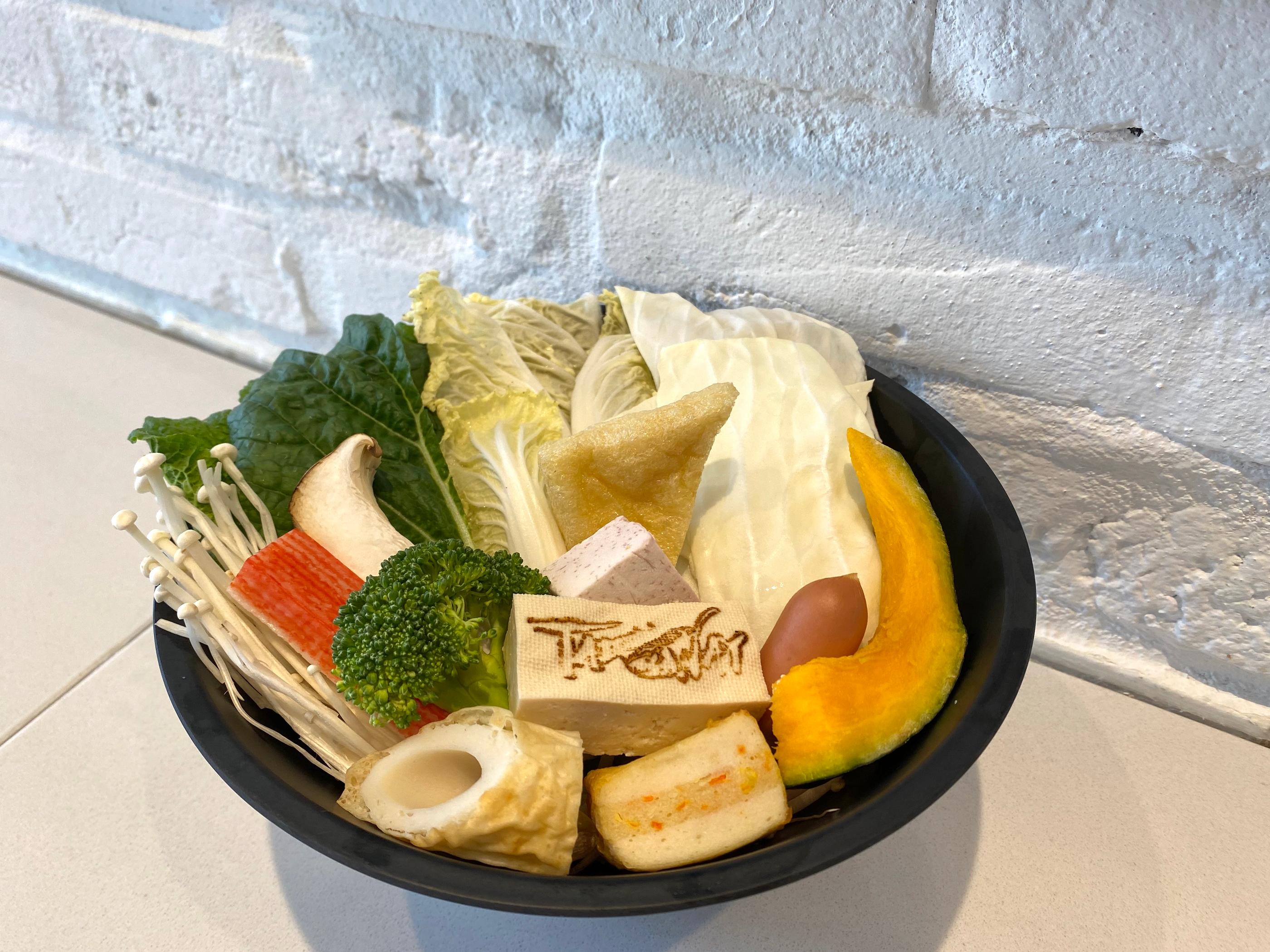 臺灣火鍋店提供的小火鍋菜盤，擺放各種彩色蔬菜和食材。