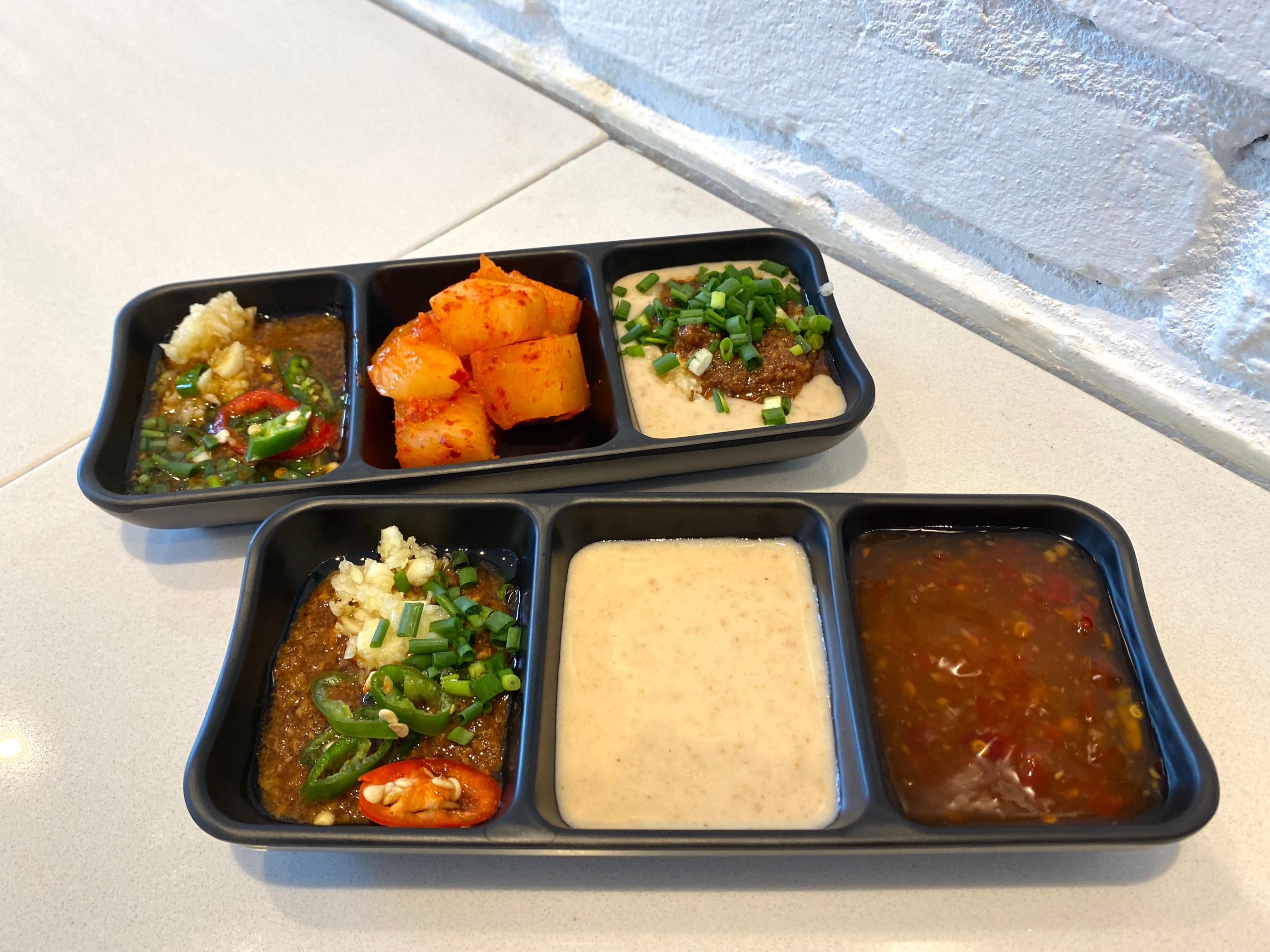 牛奶火鍋正在煮沸，一旁陳列精緻擺放的火鍋食材和薄切肉。