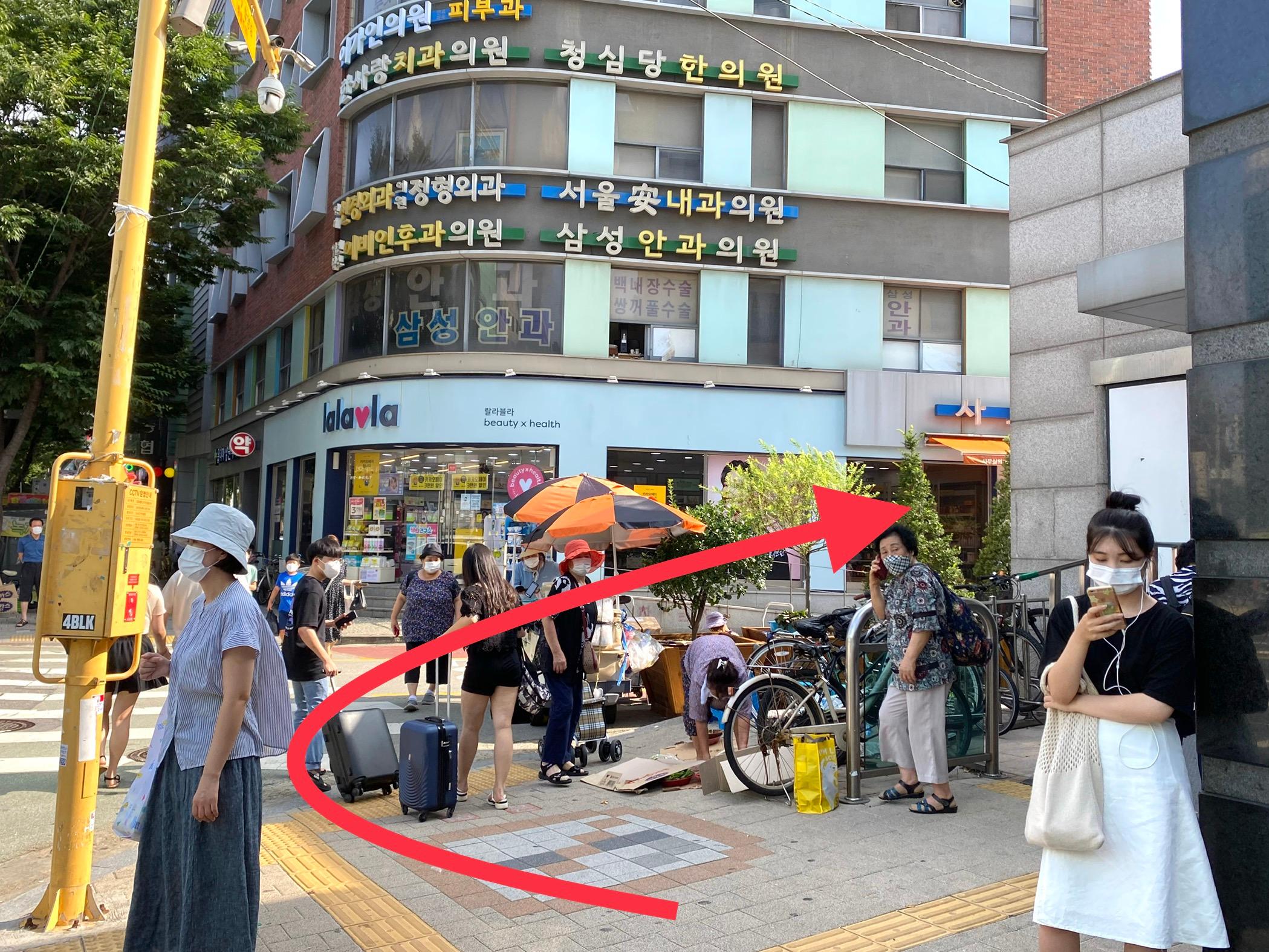 望遠地區人行道上熙攘的人群，以及一家櫥窗中展示的美妝護膚產品。