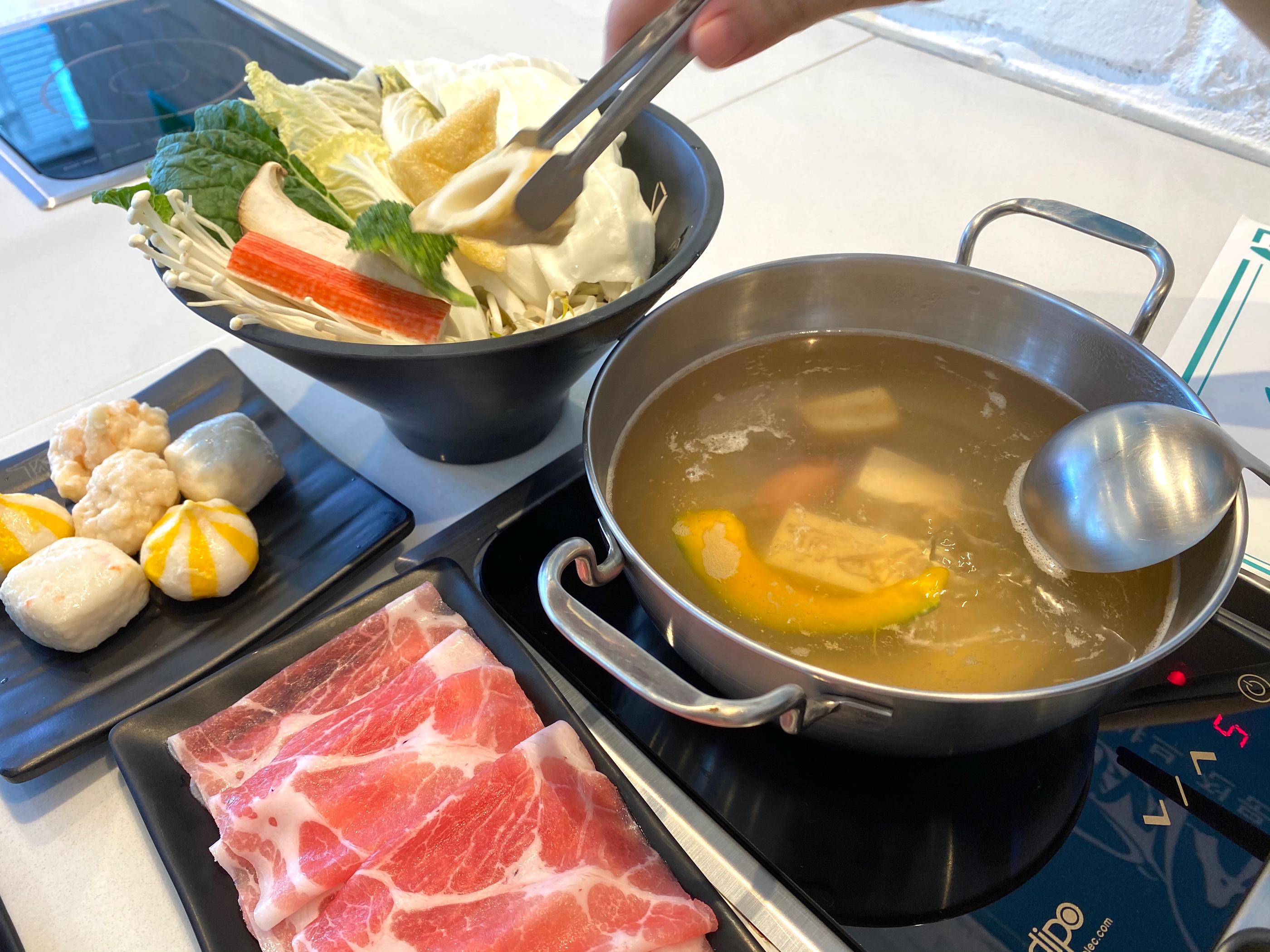 火鍋中燙熟的牛肉片撈至特製沾料中，滿足臺灣味覺感受。