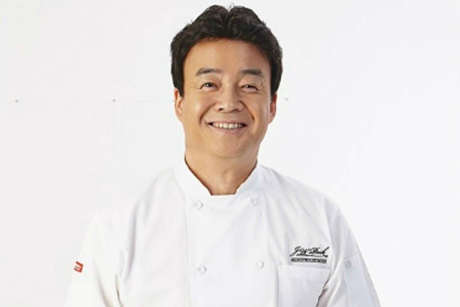 แบคจองวอนเชฟชื่อดัง สวมเสื้อเชฟสีขาวยืนโพสท่ากับพื้นหลังสีขาว