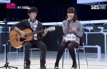 樂童音樂家在K-pop Star舞臺上演唱的場景。