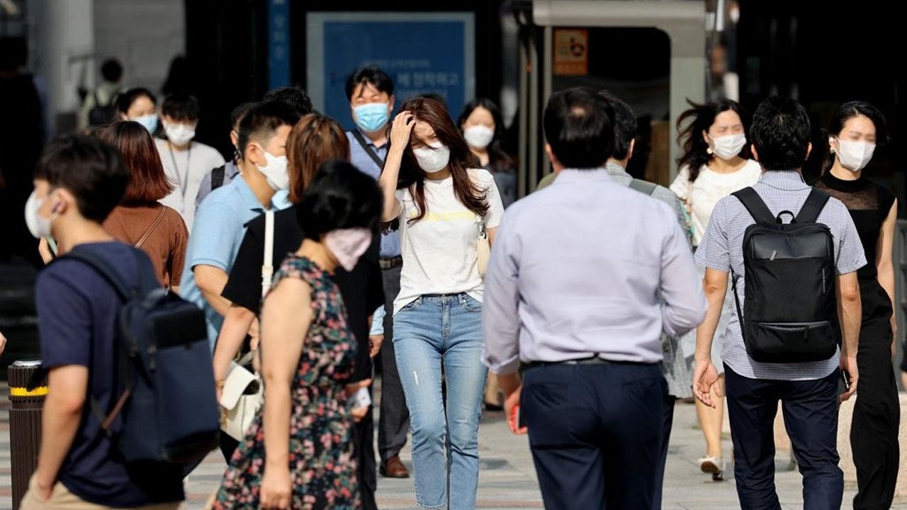 ผู้คนสวมหน้ากากเดินบนถนนในเกาหลีใต้สะท้อนสภาพชีวิตท่ามกลางการระบาดของโควิด-19ในปี 2020