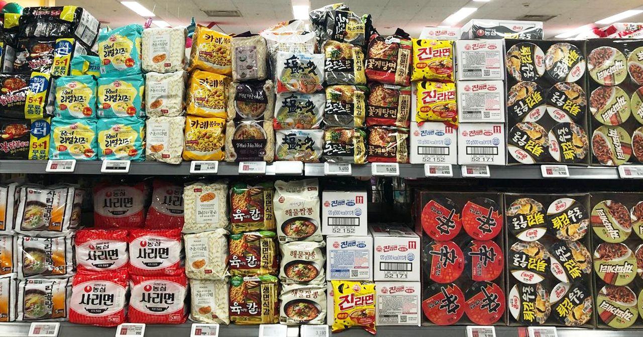 ชั้นวางสินค้าที่เต็มไปด้วยบะหมี่กึ่งสำเร็จรูปหลากหลายยี่ห้อในร้านค้าของประเทศเกาหลีใต้