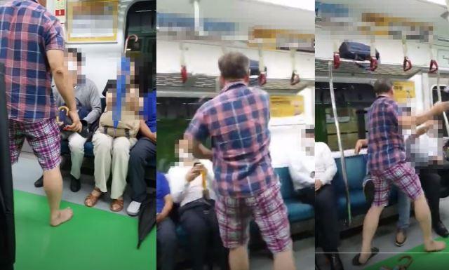 地下鉄の電車内で、ノーマスク男性が他の乗客に暴力を振るっている場面の映像キャプチャー。彼はスリッパを使って別の男性を攻撃している。