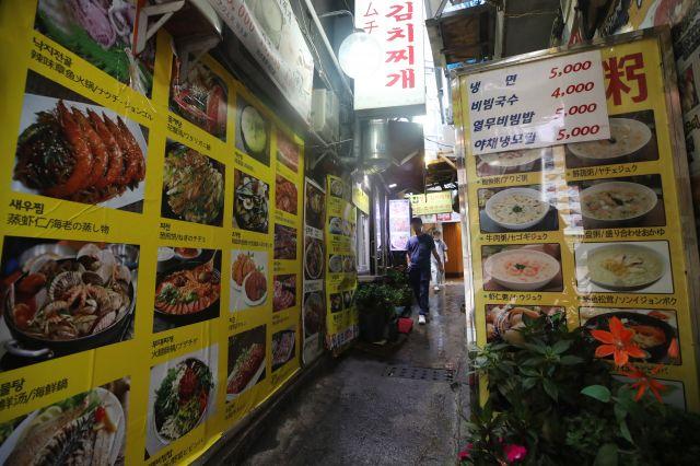 ソウル市内の飲食店通り、夕方の静けさを映し出す風景。通常は活気に満ちた通りであるが、コロナ19の影響により包装と配達のみが許可されている状況を示しています。