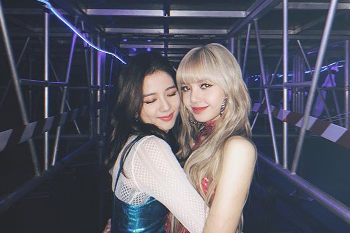 兩位BLACKPINK成員站在舞台後面穿著華麗的演出服。