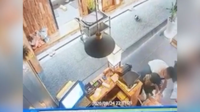 餐廳內部的監視器拍攝到一位男子跪在地上,似乎正在協助一名倒地的廚師進行急救操作。