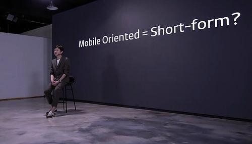 モバイルオリエンテッドの概念を説明するカカオMのシン・ジョンス本部長。モダンな展示空間での講演の様子。