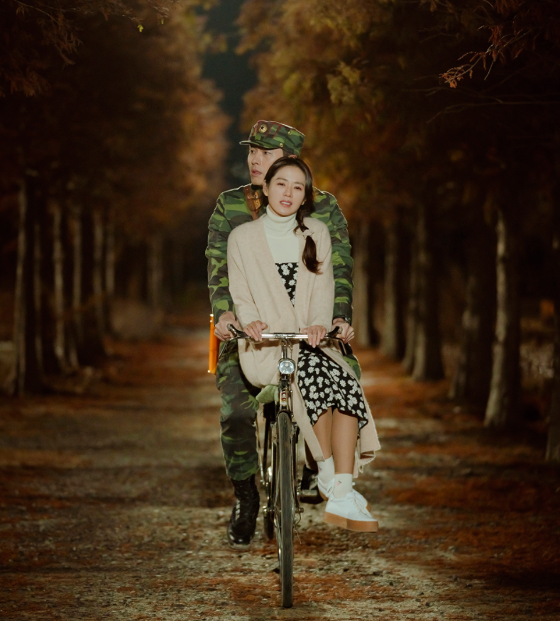 主角骑自行车，在泰安青山树木园秋季枫叶小径上，参考韩剧《爱的迫降》拍摄地