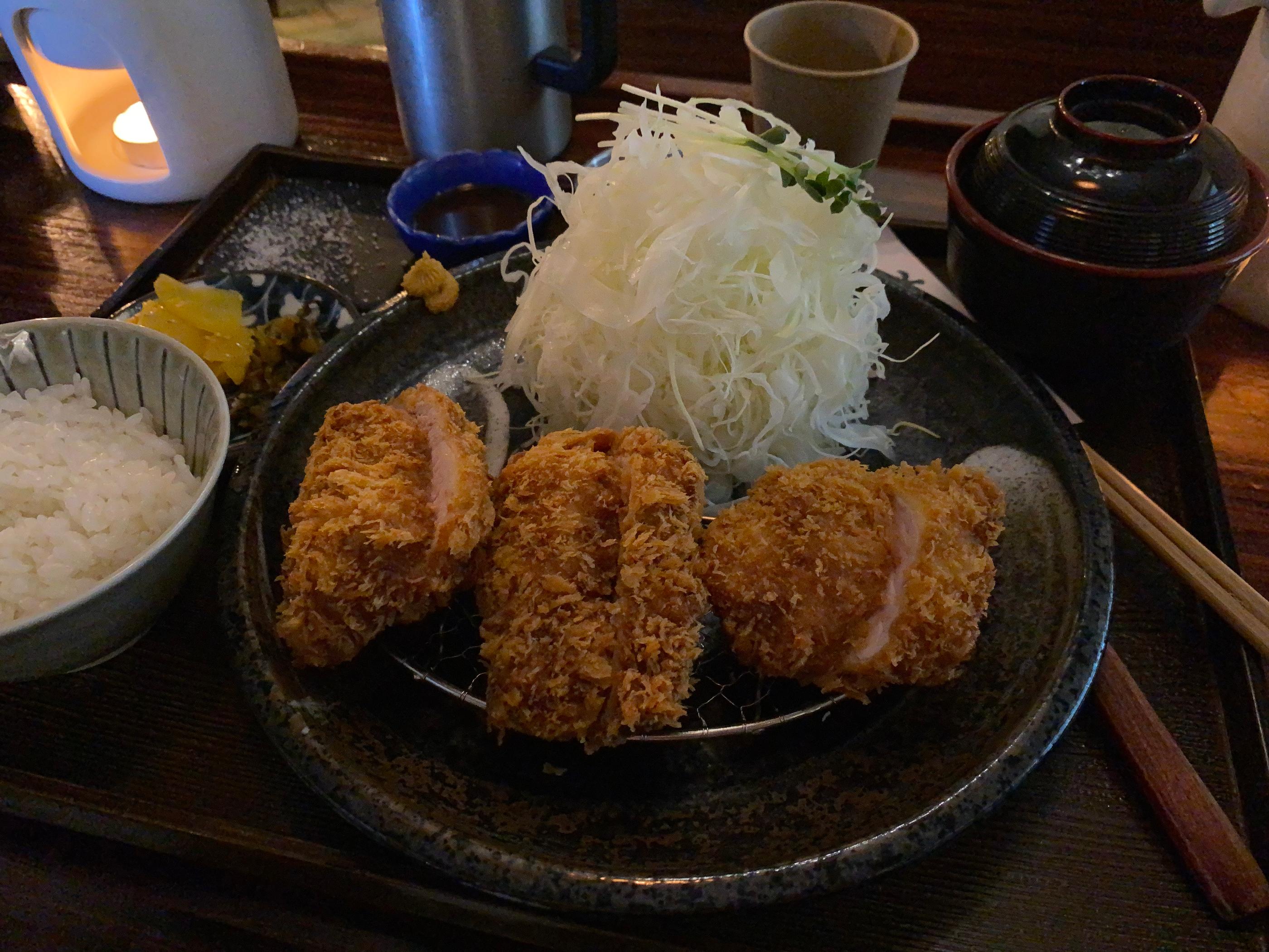 Plato de tonkatsu con guarnición de col en Crazy Katsu, listo para disfrutar.
