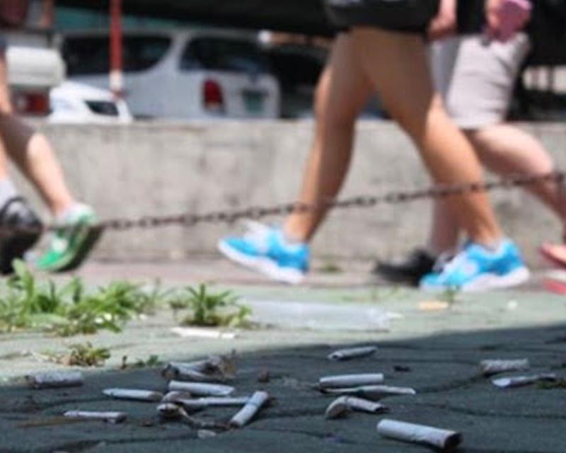 地上有很多煙頭的街道，人們在行走