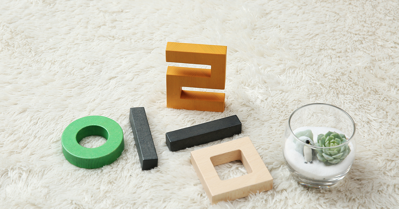 ภาพตัวอักษรไม้และแก้วใสตกแต่งวางเรียงกันบนพื้นพรม ที่สะท้อนถึงชื่อในวัฒนธรรมเกาหลี