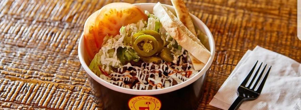 Jil'Hal Bros的美式便當，包含飯、蕃茄、生菜、橄欖和肉類，味道豐富。