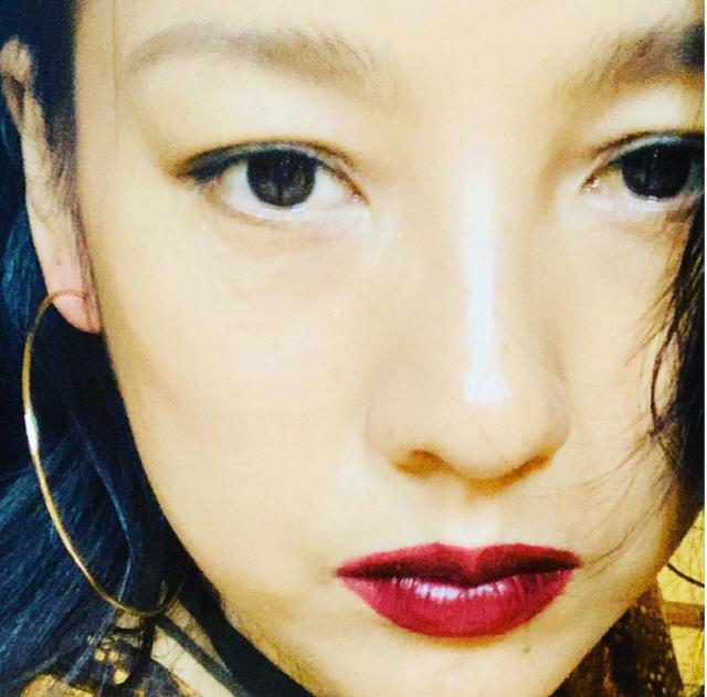 金色の大きなフープイヤリングを着用しているシンプルな女性の耳。