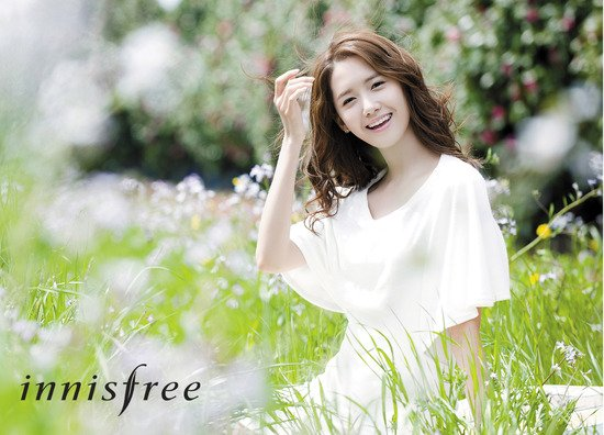 潤娥身穿白色裙子在花田中，象徵Innisfree的清新與自然形象。