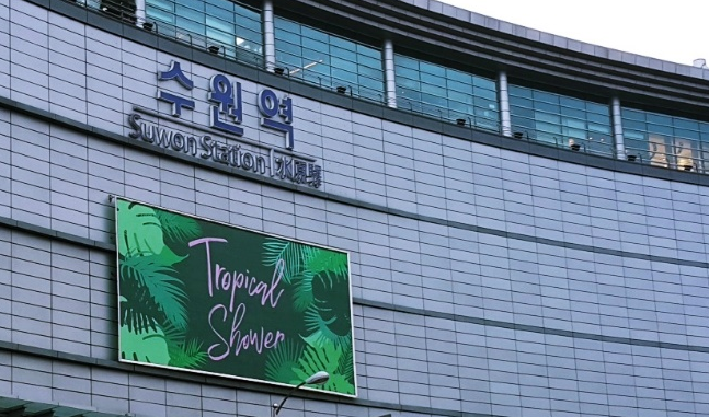 水原站建築外觀，展示著顯眼的廣告看板和建築設計。