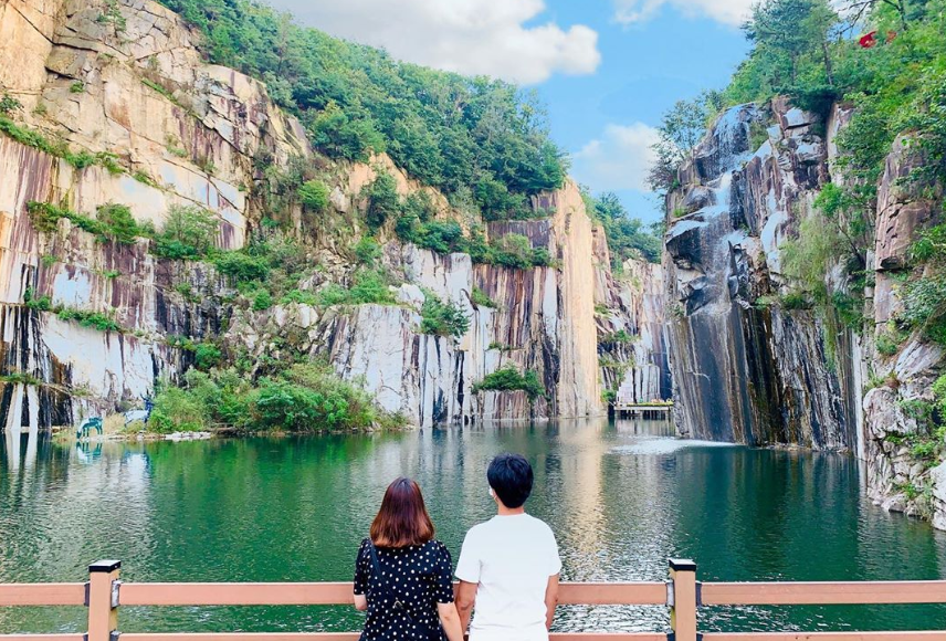 Pemandangan menakjubkan dari Lembah Seni Pocheon di Korea dengan dinding tebing granit yang menjulang tinggi dan air terjun kecil, memberikan suasana yang damai.