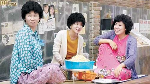 Ajumma's sitting around a basket of vegetables in Reply 1988