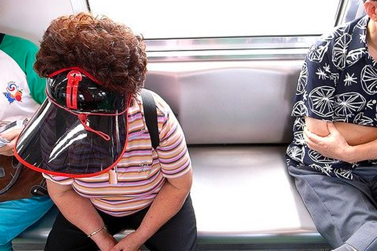 韓國阿珠媽在地鐵車廂中，戴著遮陽帽，在旅途中稍事休息。