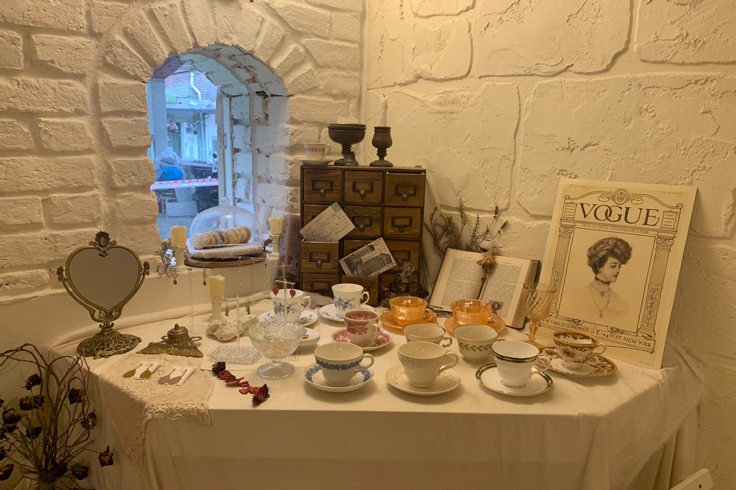 咖啡廳內部裝飾，擺放有古董風格的茶杯、燭台和裝飾品，營造出一種復古優雅的氛圍。