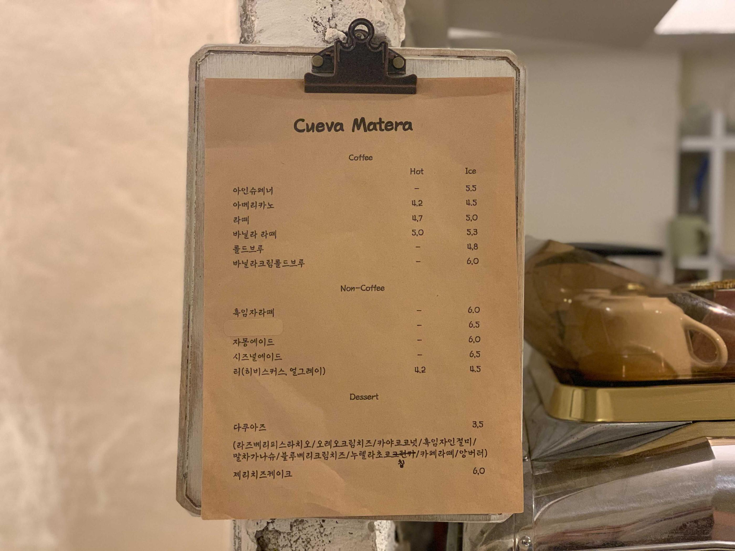 カフェ『Cuevamatera』のドリンクとデザートのメニュー。様々なコーヒーや特製ドリンク、ダックワーズなどの選べるメニューが記載されています。