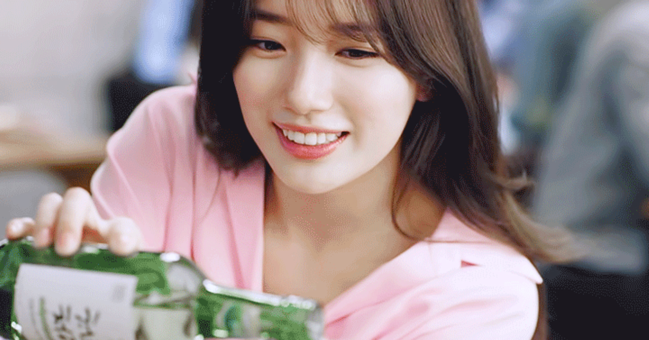 韓國電視劇中的女性角色拿著一瓶綠色燒酒的劇照。