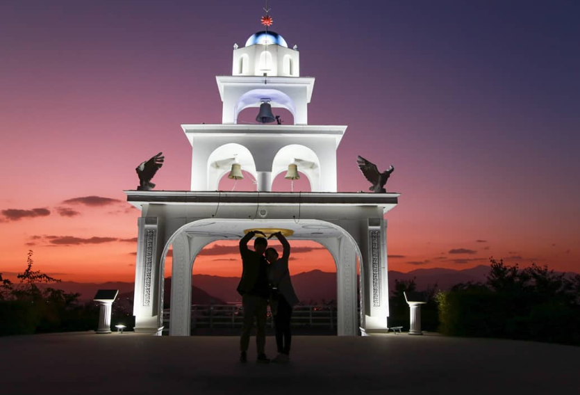 ein Paar, das vor dem Chuncheon Santorini Wahrzeichen ein Herz macht