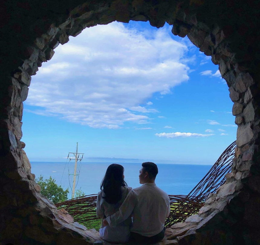 Paar posiert im Gangneung Haslla Art World, mit Blick auf das Meer
