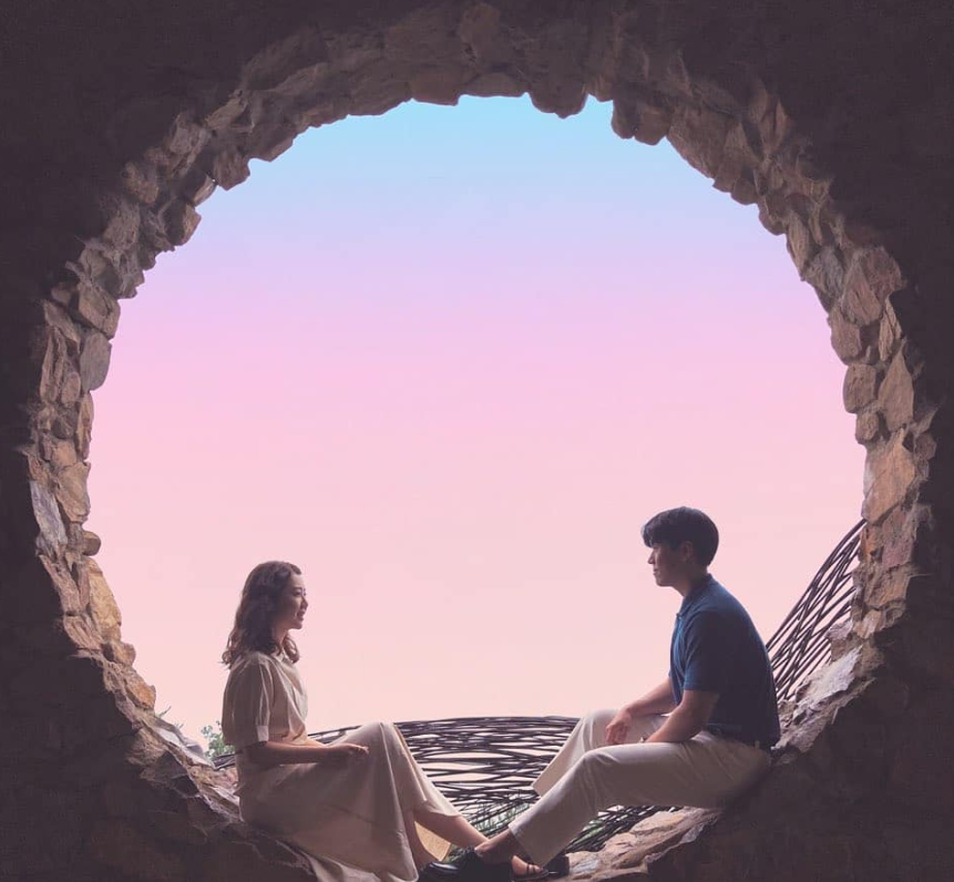 Ein Paar posiert am Fotospot des Gangneung Haslla Art World, Steinhöhle im Sonnenuntergang.