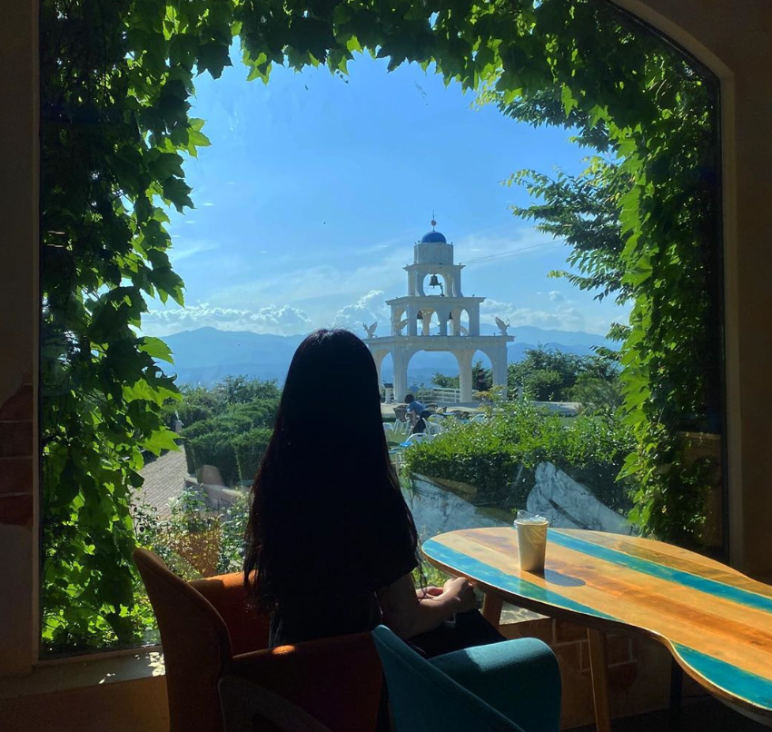 ein Mädchen schaut aus dem Fenster auf das Chuncheon Santorini Wahrzeichen