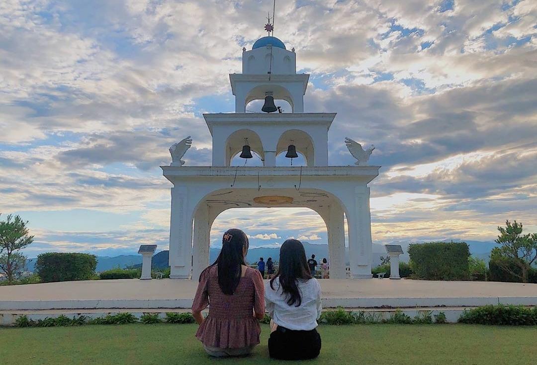 zwei Mädchen sitzen und posten vor dem Wahrzeichen von Chuncheon, Santorini