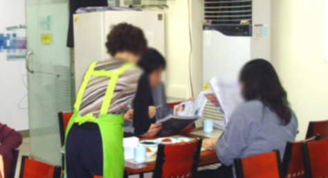 a korean lady serving food at a humble local restaurant
