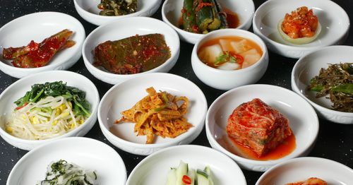 many korean side dishes on a table, korean cuisine
