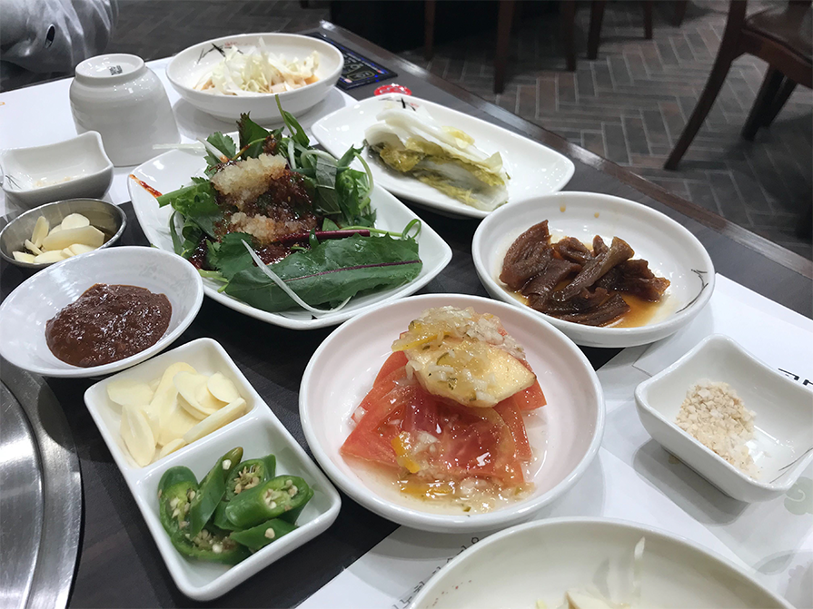 many side dishes, or banchans, served at a restaurant in korean, all about korean cuisine