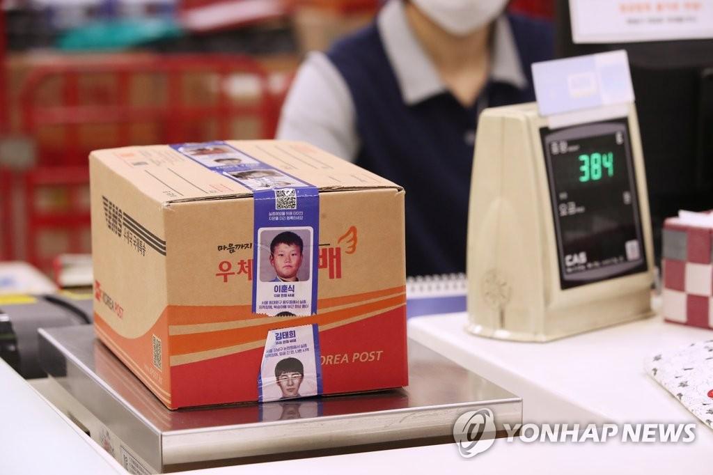 郵便局のカウンターに置かれた段ボール箱には、「HOPE TAPE」が巻きつけられ、行方不明児童の情報がプリントされています。